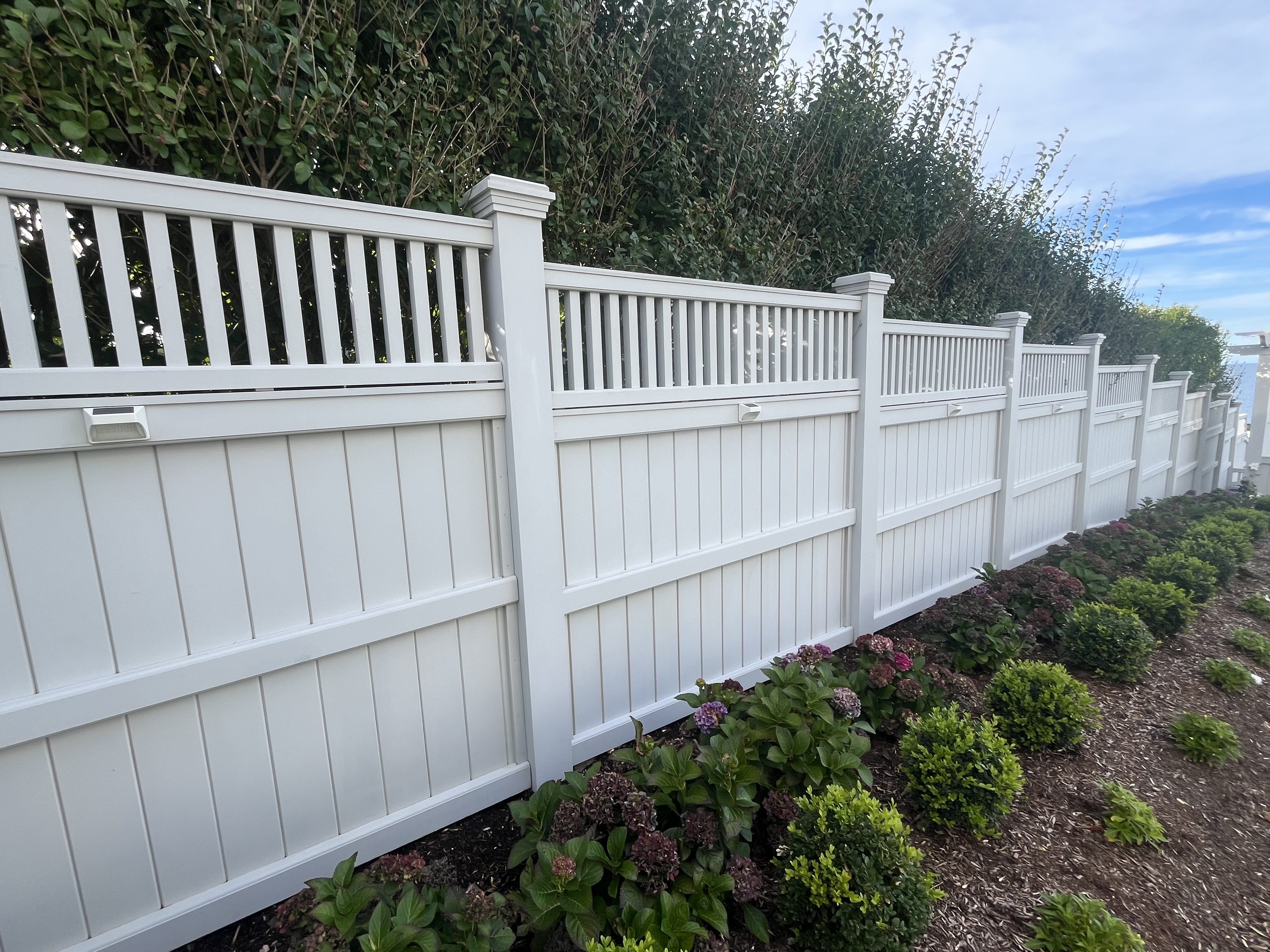 Freshly cleaned white vinyl fence, after photo